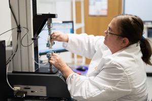 DDL technician running a seal strength test on the tensile frame